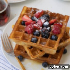Fluffy Gluten-Free Waffles 12 Close up of crispy golden waffles with blueberries, raspberries, strawberries.