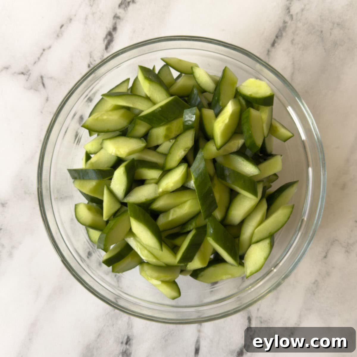 Crisp Cucumber Dill Feta Medley 5 A glass bowl of chopped cucumbers ready for salad.