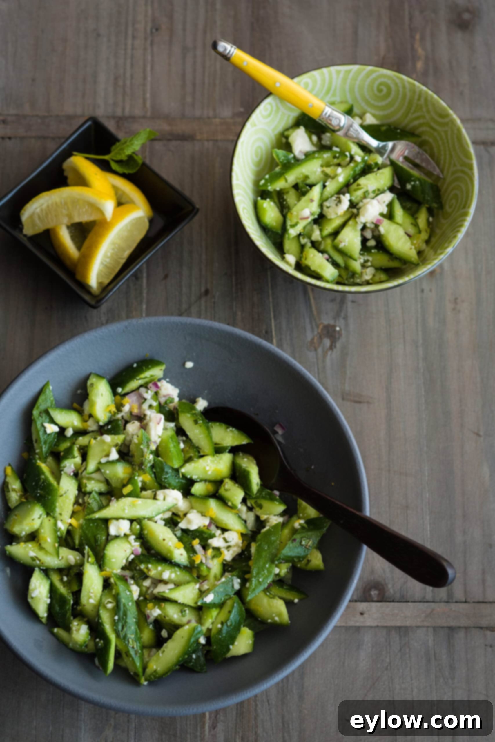 Crisp Cucumber Dill Feta Medley 9 A gray bowl of chopped cucumbers with lemon zest, feta cheese, fresh herbs and red onion.