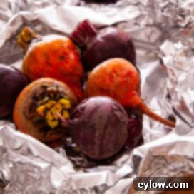 Colorful red and golden roasted beets in aluminum foil.