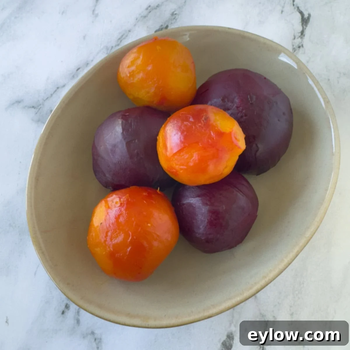 An oval bowl with roasted red and gold beets ready to enjoy.