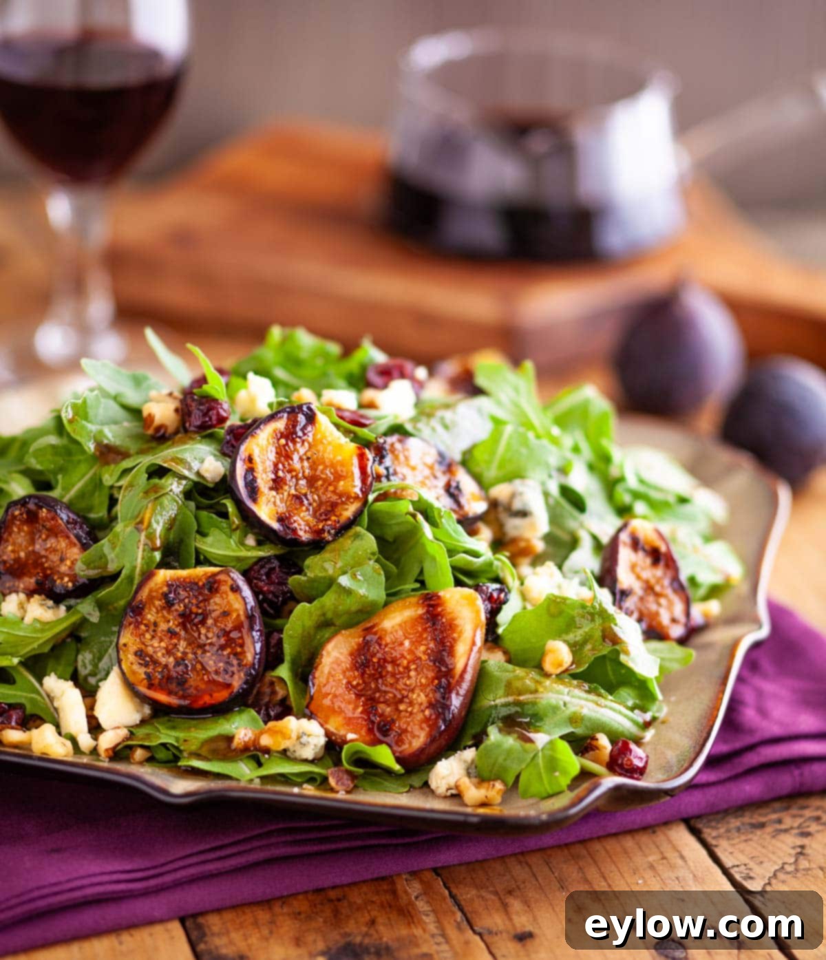 Fresh fig salad with grilled figs, mixed greens, creamy goat cheese, chopped walnuts, and a vibrant balsamic dressing.