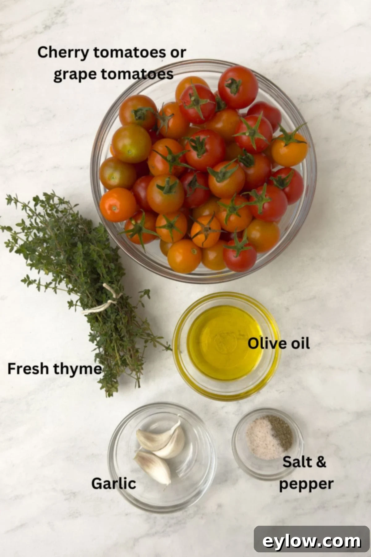 Aromatic Garlic and Thyme Roasted Tomatoes 3 Ingredients for roasted cherry tomatoes on the counter in glass bowls. Fresh cherry tomatoes, olive oil, garlic cloves, and a sprig of thyme are neatly arranged.