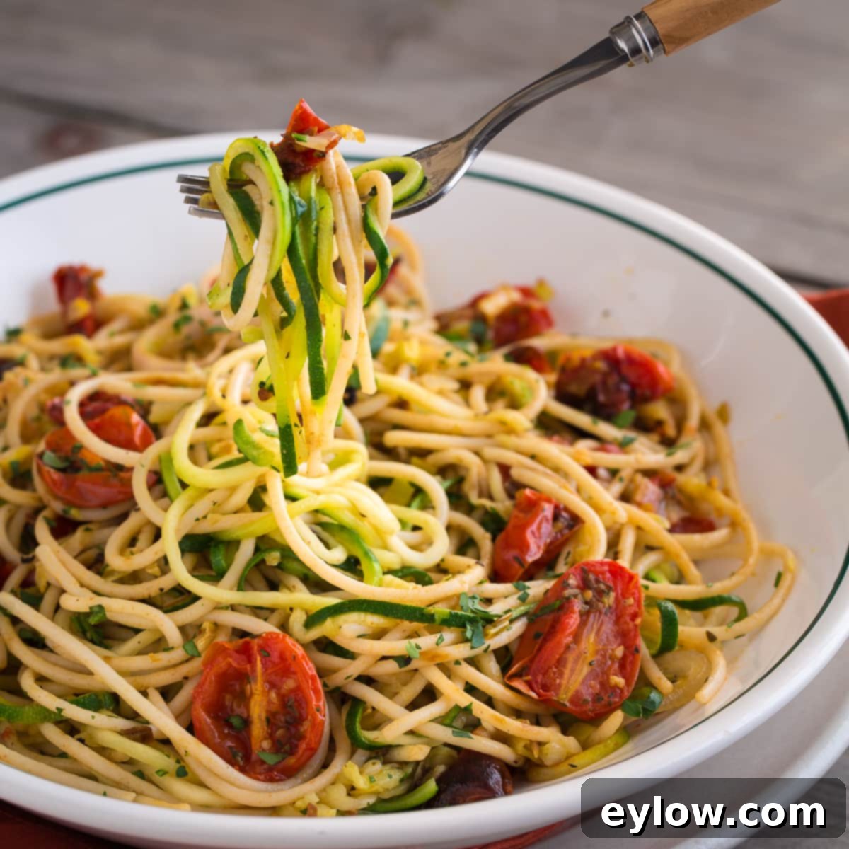 Aromatic Garlic and Thyme Roasted Tomatoes 8 Zucchini noodles with roasted tomatoes in a bowl. A vibrant dish showing fresh zucchini pasta intertwined with golden roasted cherry tomatoes.