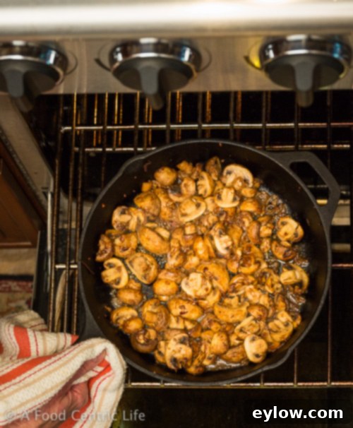 Close-up of finished steakhouse mushrooms, roasted to perfection, garnished with fresh herbs.