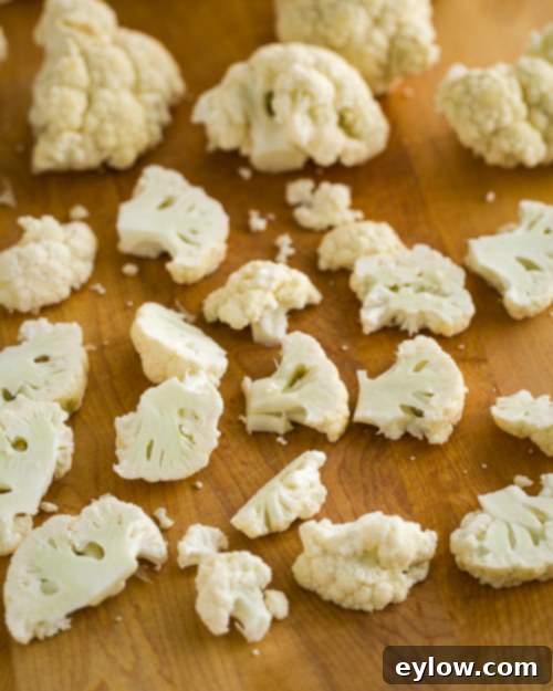 Crispy Parmesan Cauliflower 3 Scattered cauliflower florets on a cutting board.