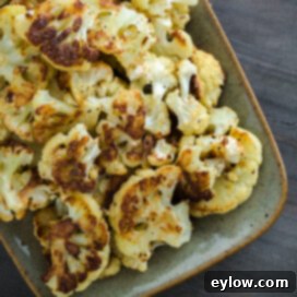 Crispy Parmesan Cauliflower 6 A platter of roasted cauliflower with golden brown edges and parmesan cheese.