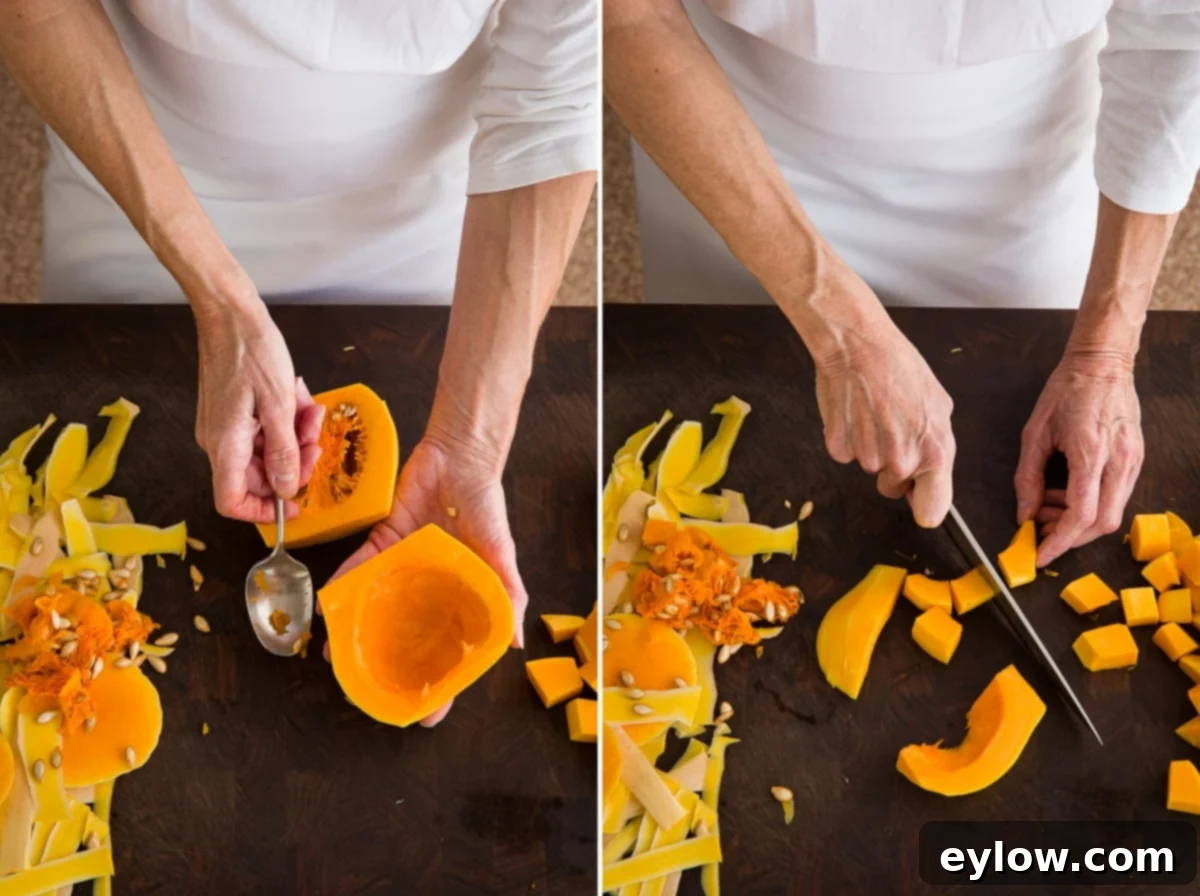 A cook carefully scooping out the seeds and fibrous material from a halved butternut squash using a spoon.