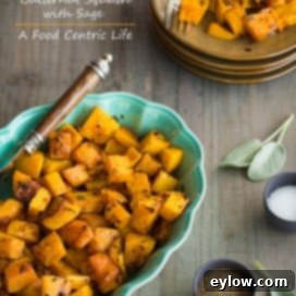 Golden roasted butternut squash with fresh sage in a serving bowl.