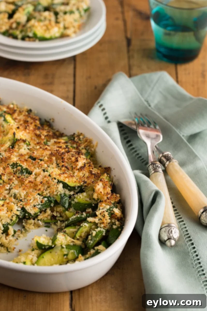 Golden Parmesan Zucchini Gratin 2 Easy zucchini casserole with a golden cheesy crust in a white oval casserole, ready to be served.