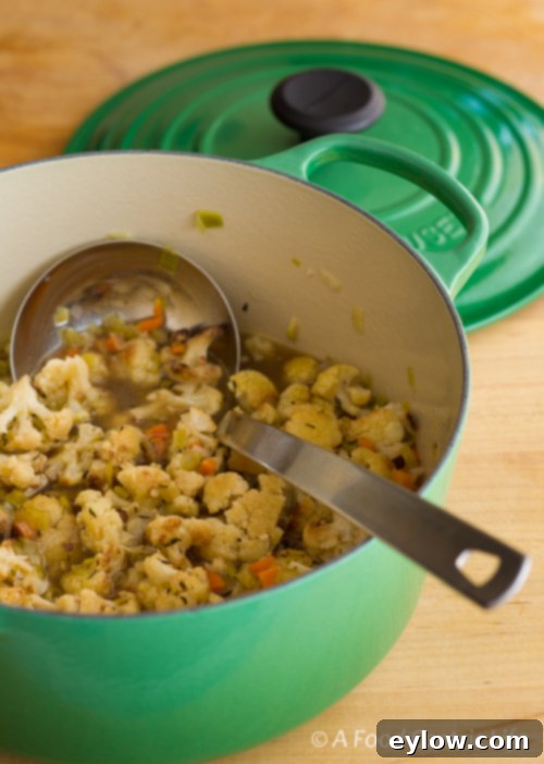 Cauliflower soup in a big green dutch oven before pureeing.