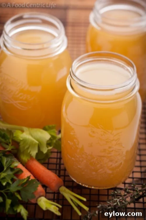 Glass jars of golden finished chicken bone broth.