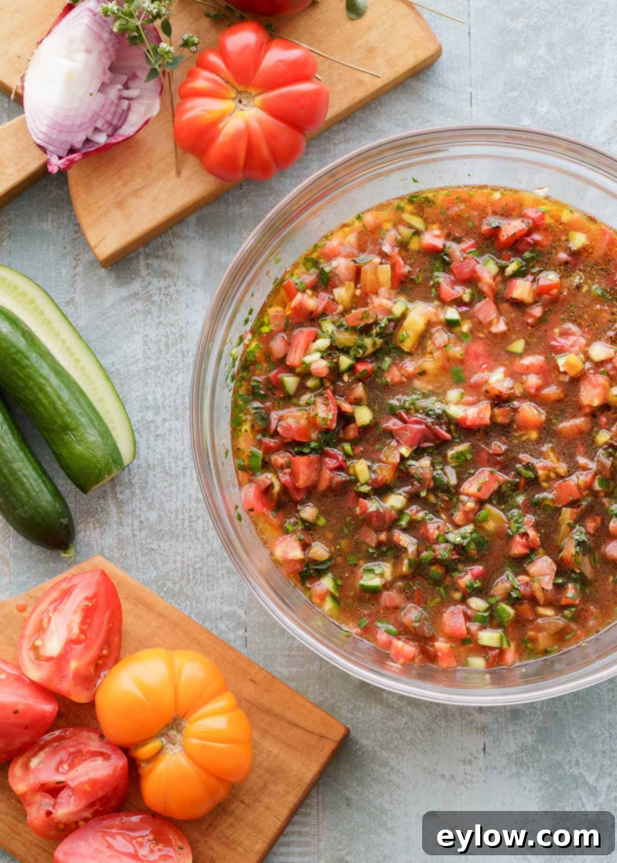 gazpacho tomato soup | AFoodCentricLife.com A large glass bowl of chunky gazpacho soup with tomatoes and veggies before blending.