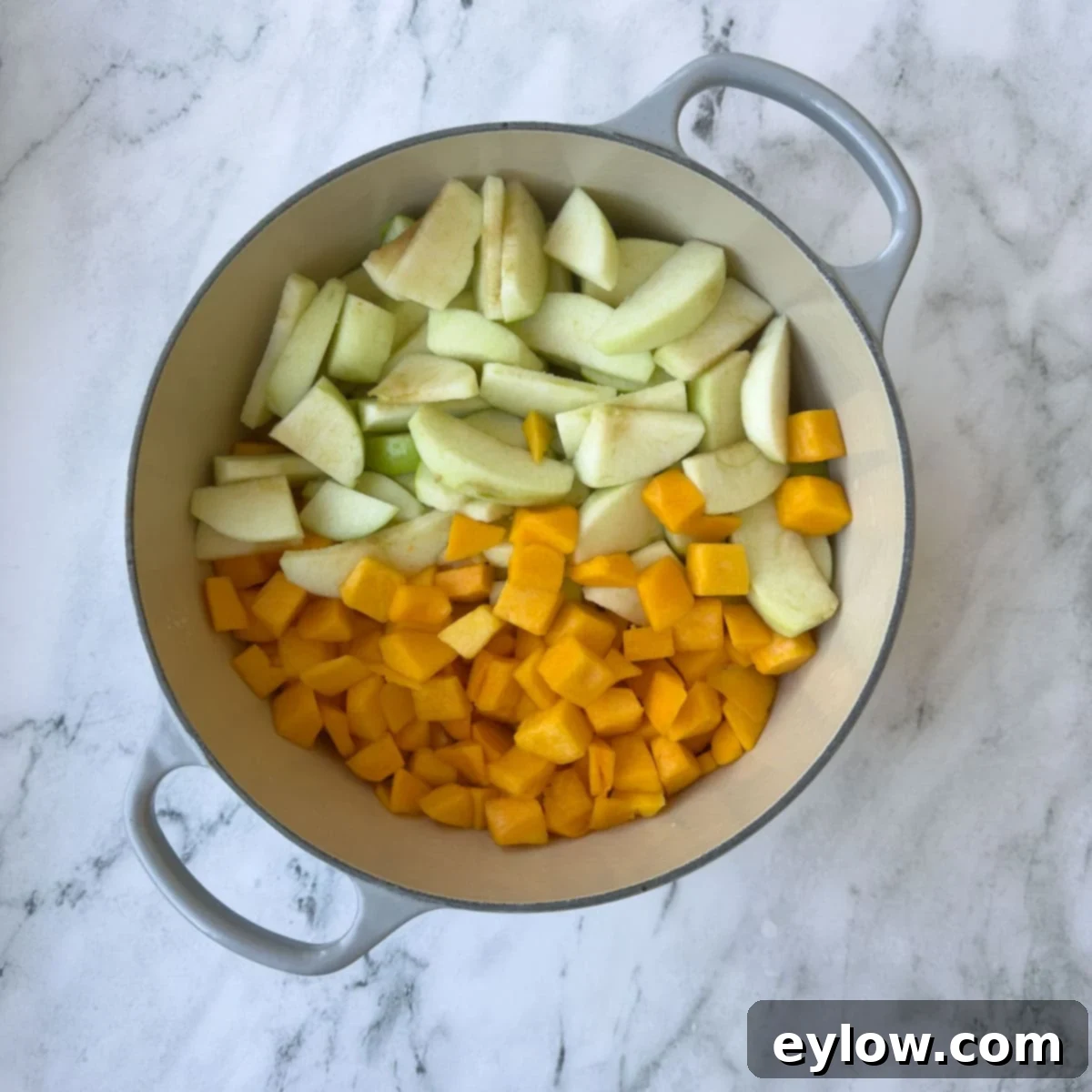Velvety Butternut Apple Comfort Soup 4 Chopped green apples and butternut squash pieces in a large gray pot, ready for cooking on a stovetop.