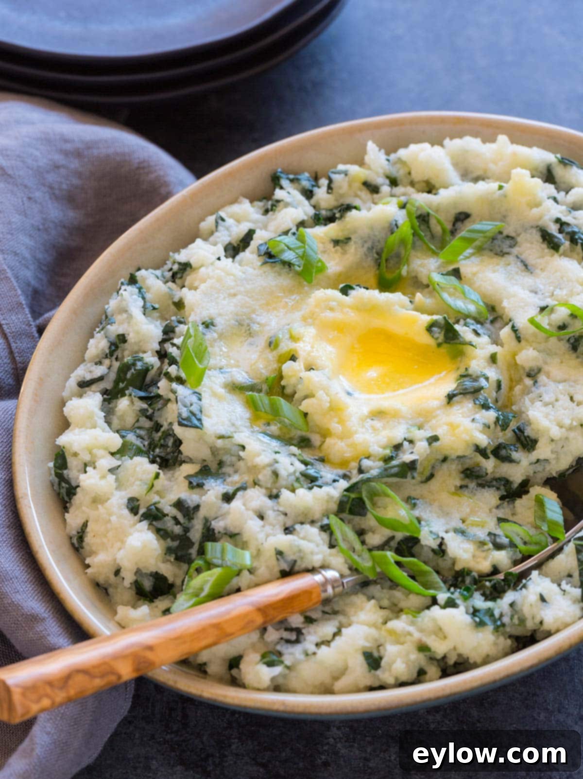 A bowl of cauliflower colcannon with kale and butter.