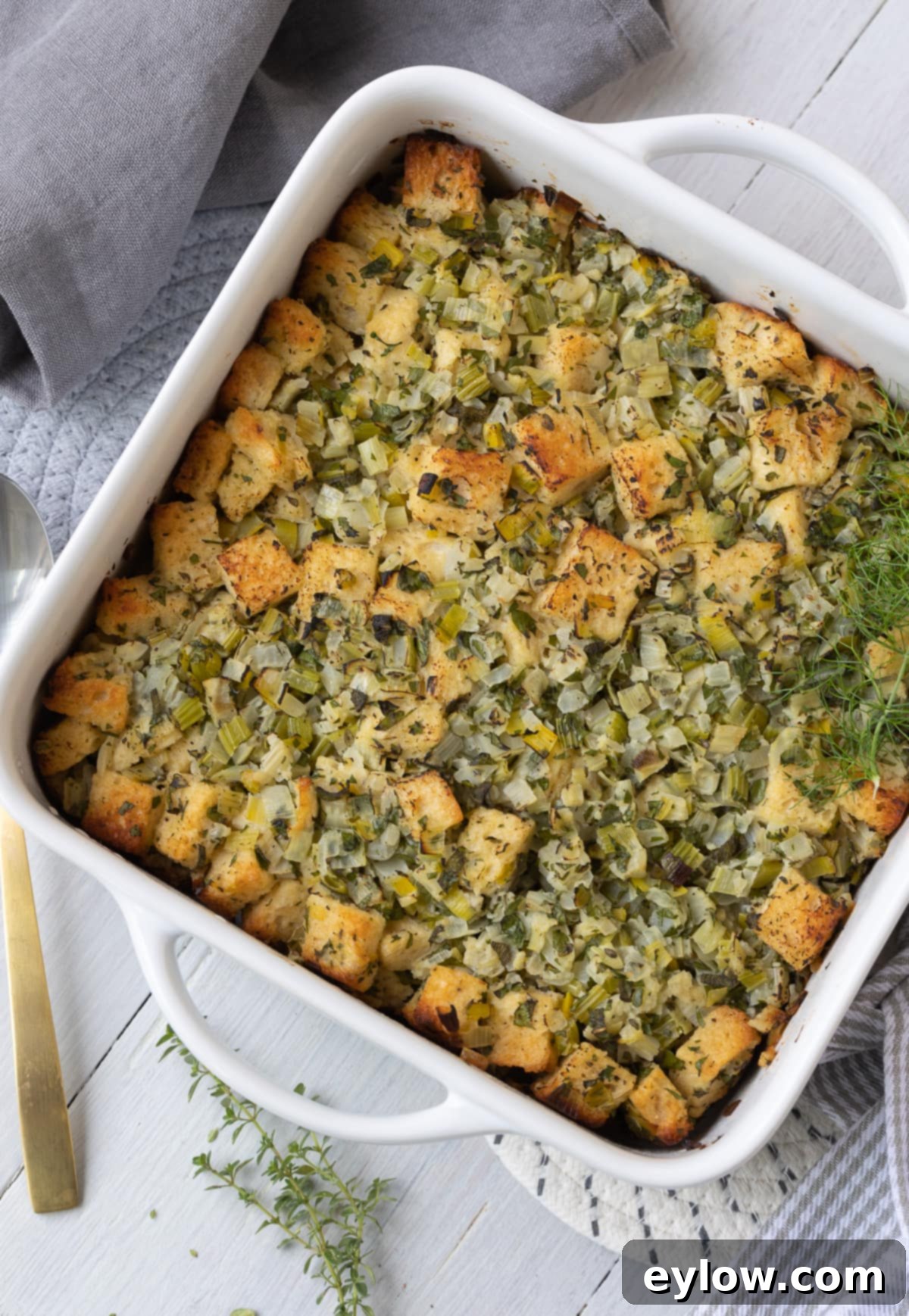 Golden-topped baked Thanksgiving stuffing in a casserole dish, ready to be served.