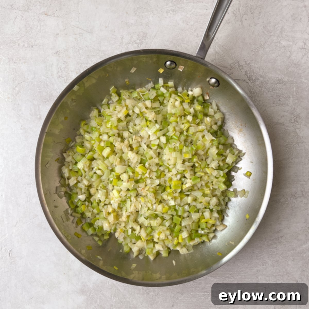 The cooked, tender vegetables for the stuffing are shown in a pan, ready for the next step of mixing.
