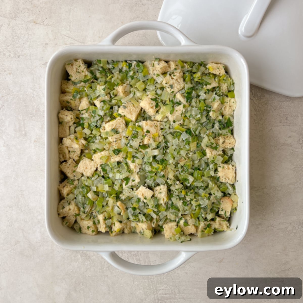 Gluten-free stuffing mixture perfectly arranged in a casserole dish, covered with foil and ready for baking.
