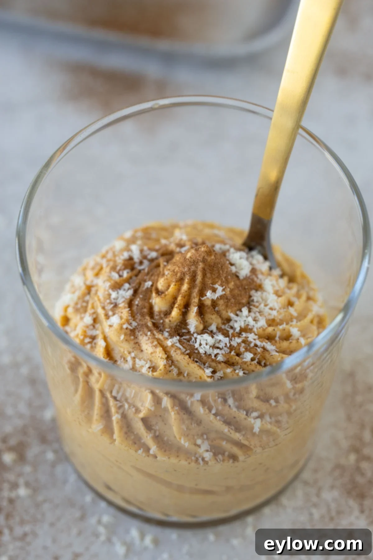 Velvet Pumpkin Mousse No-Bake Treat 12 Looking into a dessert glass of pumpkin mousse, garnished with white chocolate.