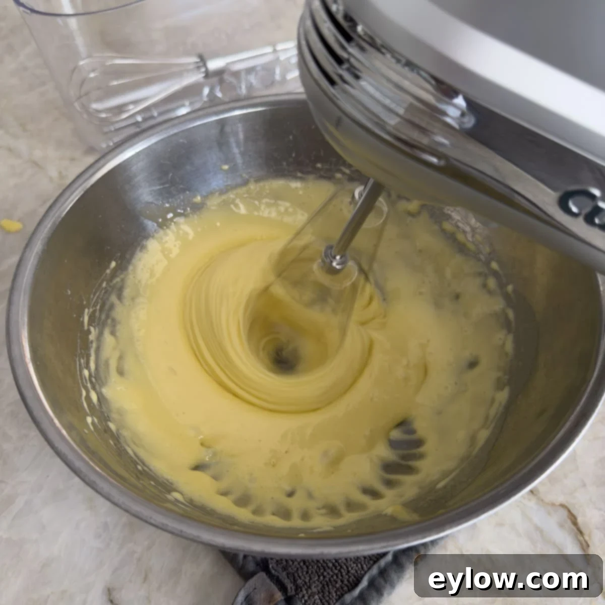 Velvet Pumpkin Mousse No-Bake Treat 8 Cooling cooked egg yolks with a hand mixer in motion, creating a light texture.