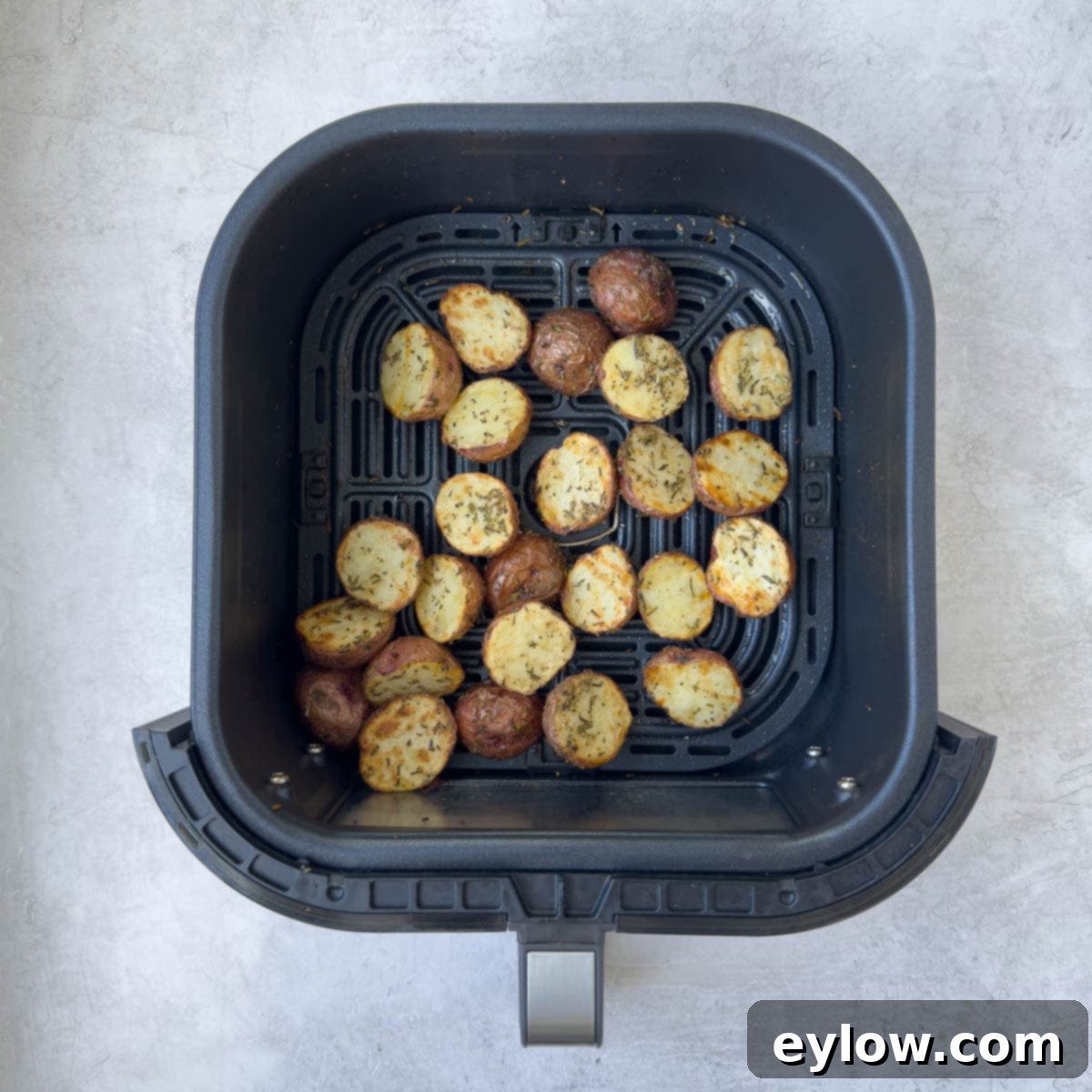 Golden Crispy Red Potatoes: Air Fried or Oven Roasted 6 Crispy golden brown red potatoes in a black air fryer basket.
