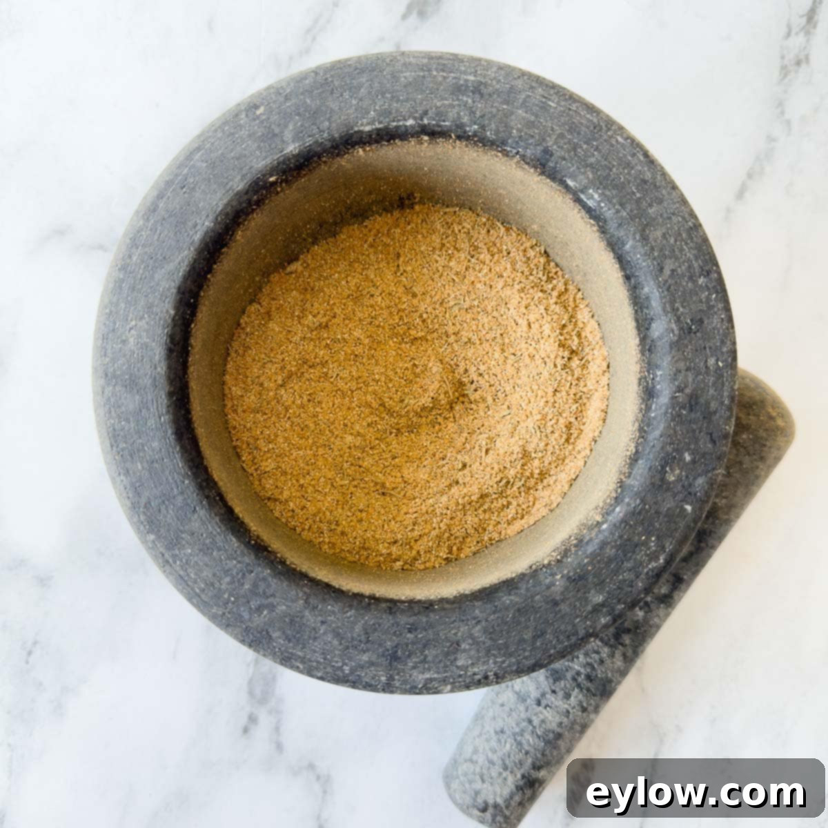 Turkey seasoning rub blended together in a gray mortar and pestle.